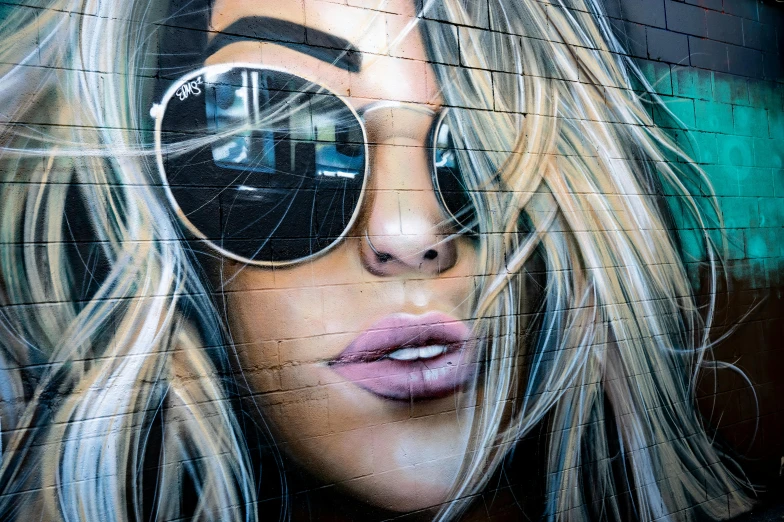 a painting of a woman with sunglasses on a wall, graffiti art, inspired by Sandra Chevrier, trending on pexels, street art, close up of a blonde woman, lachlan bailey, tourist photo, air brush art