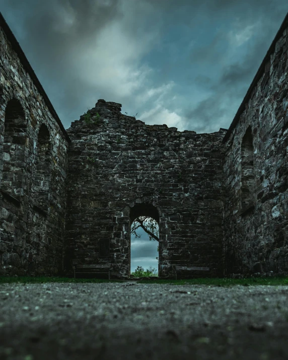 an old stone building with a dark sky in the background, an album cover, pexels contest winner, romanesque, ruined, high quality photo, arch, an abandoned old