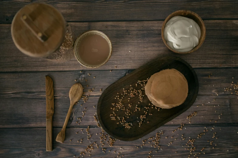 a plate of food sitting on top of a wooden table, a picture, clay material, milk and mocha style, background image, papyrus