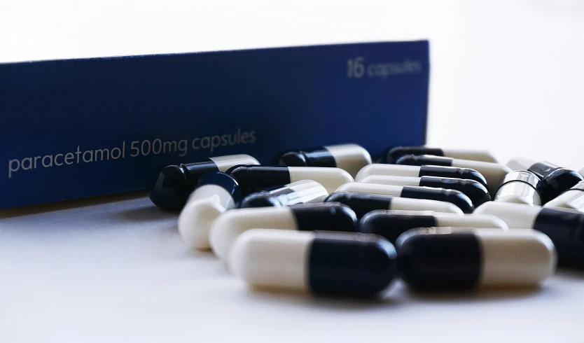 a bunch of pills sitting on top of a table, black and blue, sleek black and white, still in package, shot with sony alpha 1 camera