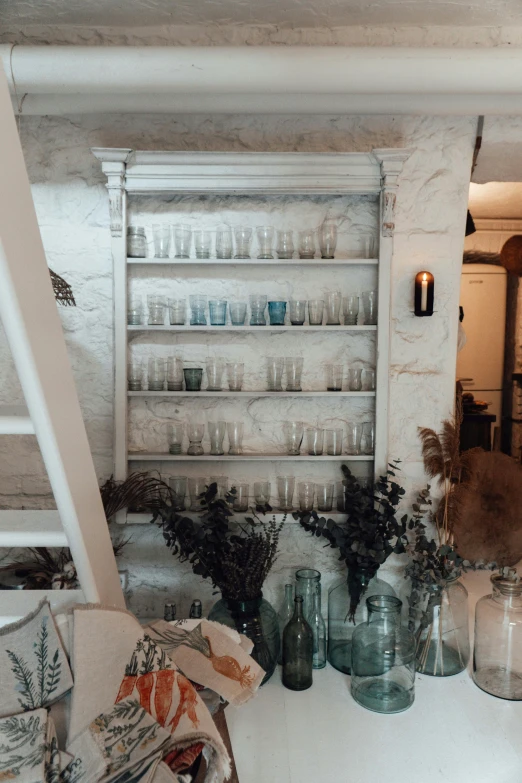 a bunch of vases sitting on top of a table, apothecary, ladders, cafe lighting, white marble interior photograph
