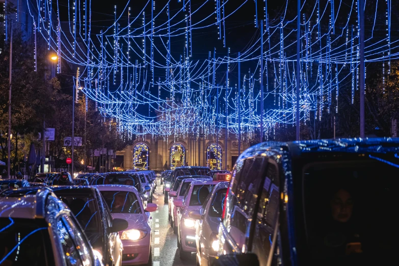 a street filled with lots of cars covered in blue lights, a photo, square, festive, thumbnail, yulia nevskaya