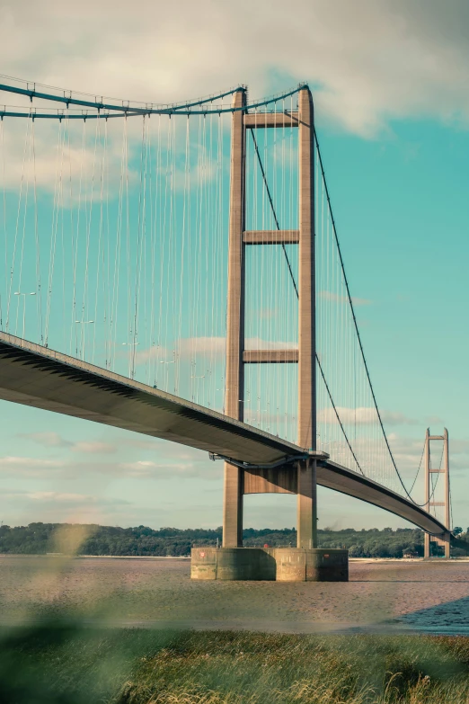 a large bridge over a body of water, by John Henderson, unsplash, huge support buttresses, 1980s photograph, simplistic, uk