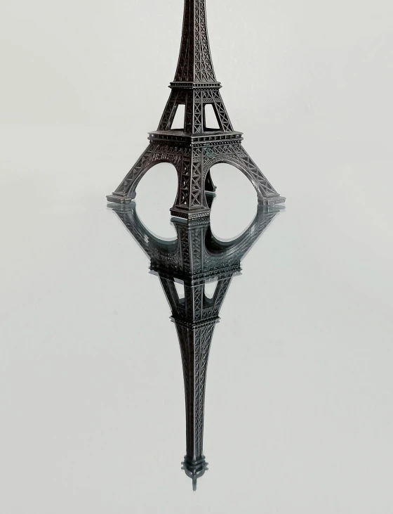 a black and white photo of the eiffel tower, a surrealist sculpture, by Bernard D’Andrea, optical illusion, detailed product shot, mirrored, black fork, made of wrought iron