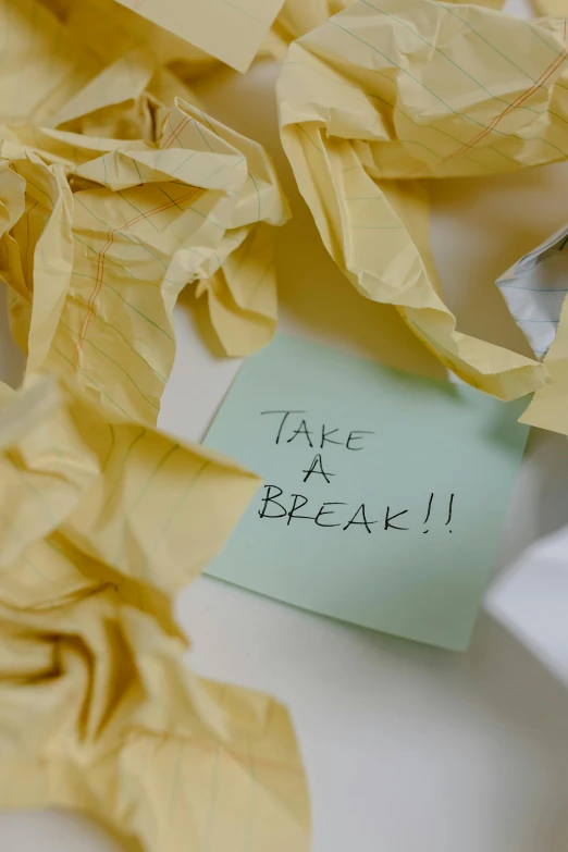 a piece of paper sitting on top of a table, by Bertram Brooker, pexels, happening, back breaker, yellow, breathe, organized