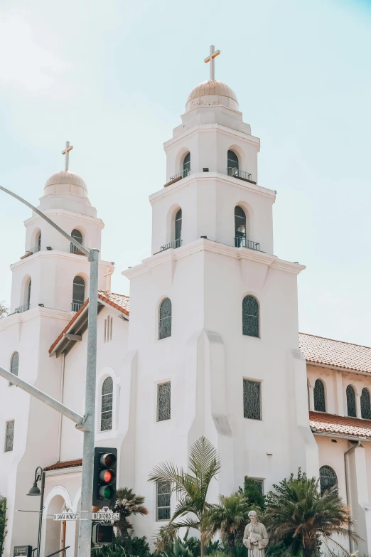 a large white church sitting on the side of a road, trending on unsplash, the city of santa barbara, art deco buildings, square, two stories