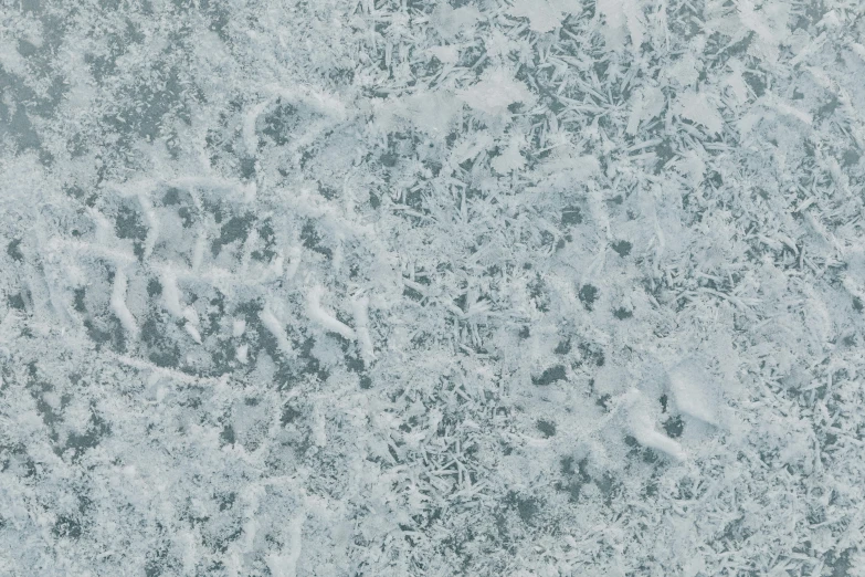 a man riding a snowboard down a snow covered slope, an album cover, inspired by Vija Celmins, trending on pexels, 4 k seamless mud texture, blue gray, glistening seafoam, made of ice