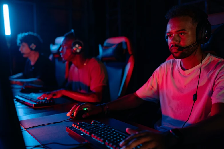 a man wearing headphones sitting in front of a computer, team ibuypower, red and blue neon, entertaining, background image