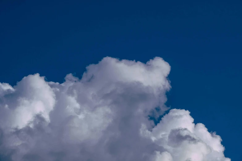 a jetliner flying through a cloudy blue sky, an album cover, unsplash, minimalism, giant cumulonimbus cloud, ignant, high definition photo, sitting in a fluffy cloud