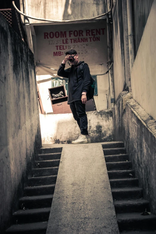 a man walking down a set of stairs, an album cover, inspired by Gang Hui-an, pexels contest winner, graffiti, in style of lam manh, looking towards camera, lo-fi, techwear