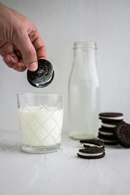 someone sprinkles oreo cookies into a glass of milk, unsplash, australian, jen atkin, silo, white