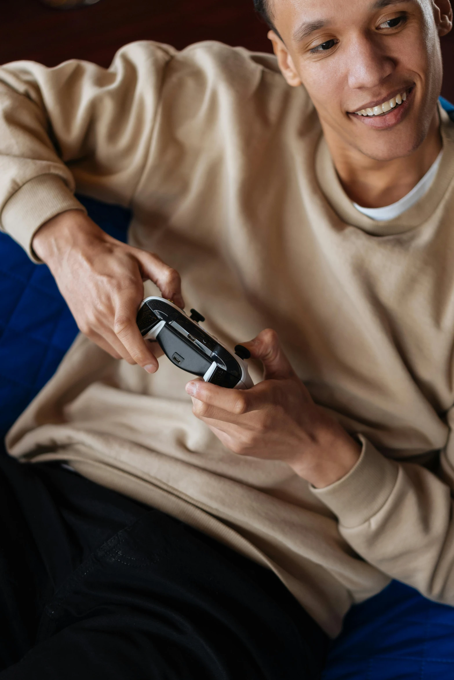 a man sitting on a couch holding a video game controller, unsplash, happening, style game square enix life, black main color, black, schools