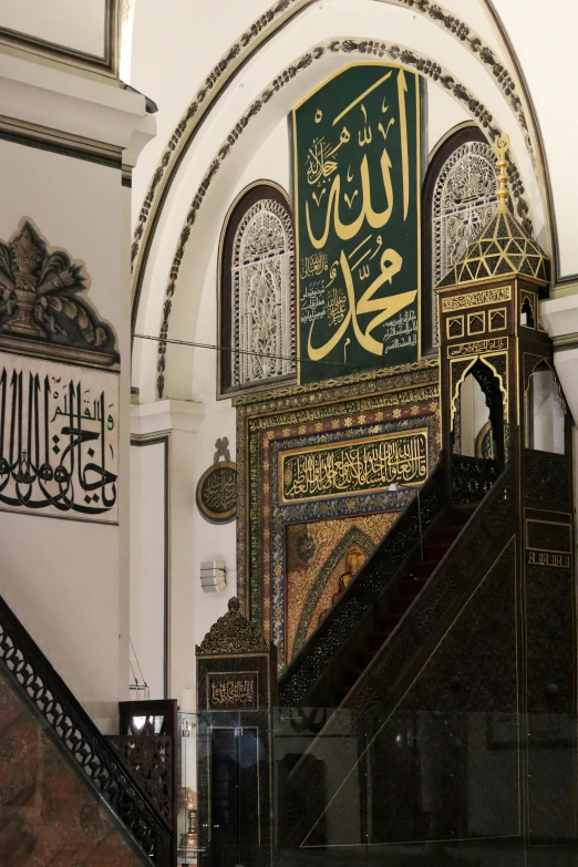 a picture of the inside of a building, inspired by Abdullah Gërguri, hurufiyya, gold and black color scheme, intricate writing, black and green scheme, staircase