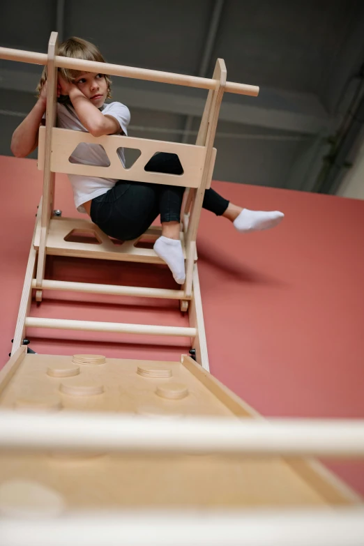 a woman sitting on top of a wooden chair, by Nina Hamnett, process art, activity play centre, airborne view, workout, square