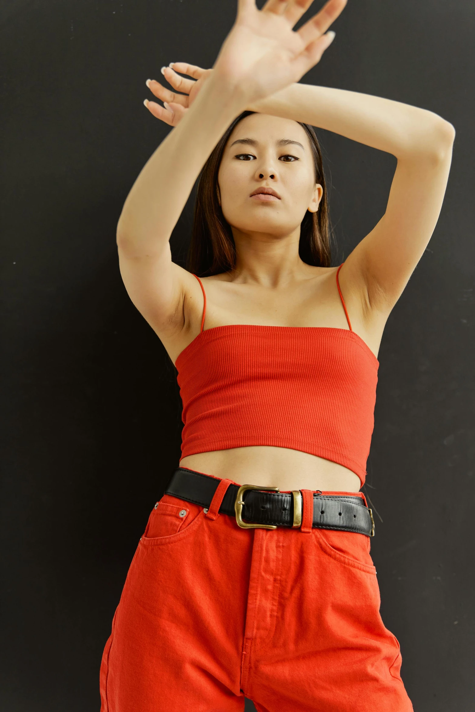 a woman in a red top posing for a picture, an album cover, inspired by helen huang, trending on pexels, belts, wearing : tanktop, curated collections, leather clothing