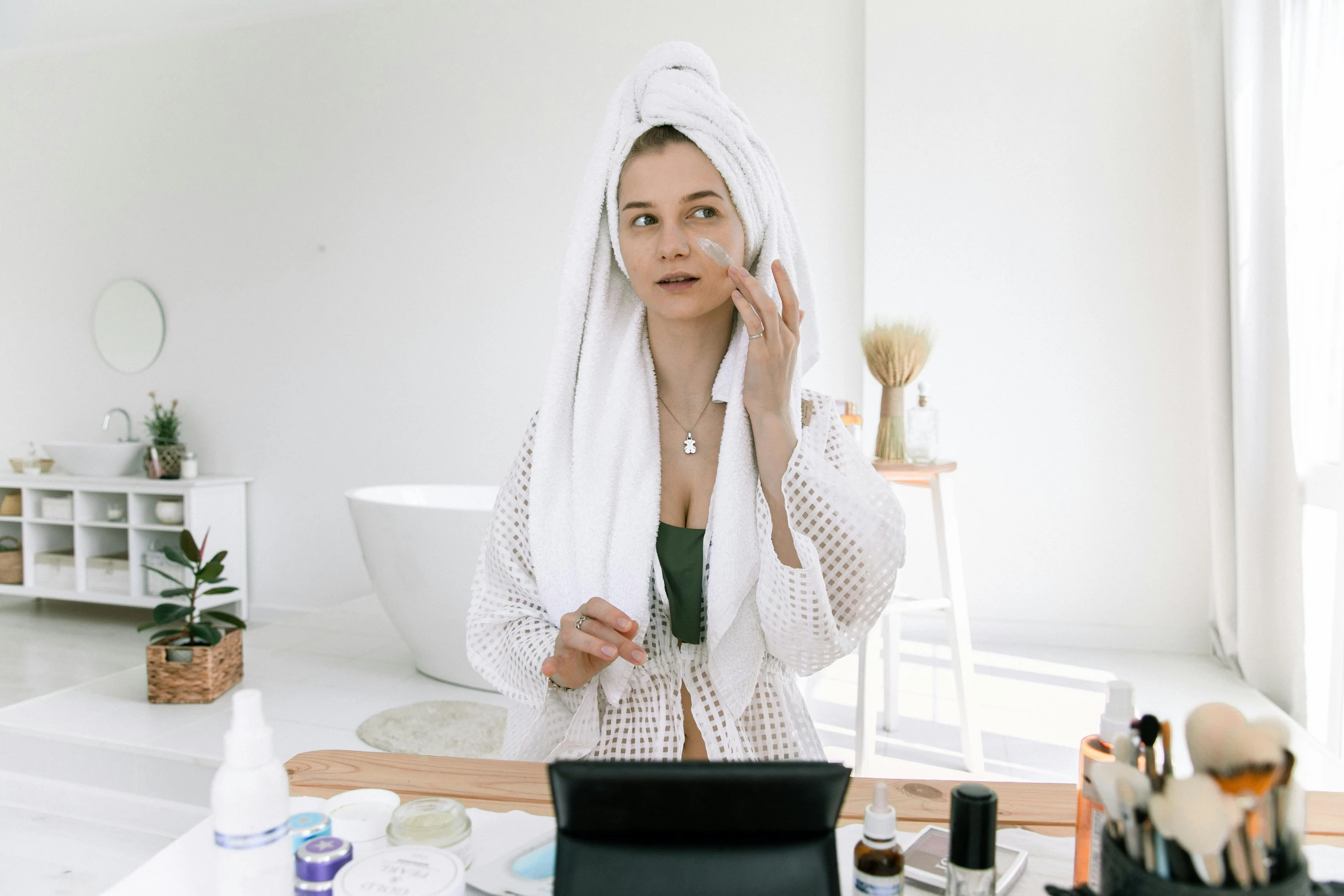 a woman in a bathrobe talking on a cell phone, by Emma Andijewska, trending on pexels, happening, white face makeup, on a white table, oils, skincare