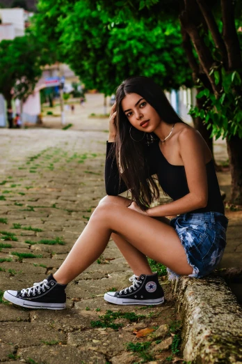 a woman sitting on top of a tree stump, a portrait, by Luis Miranda, pexels contest winner, wearing red converse shoes, brazilan supermodel, a beautiful teen-aged girl, on a street