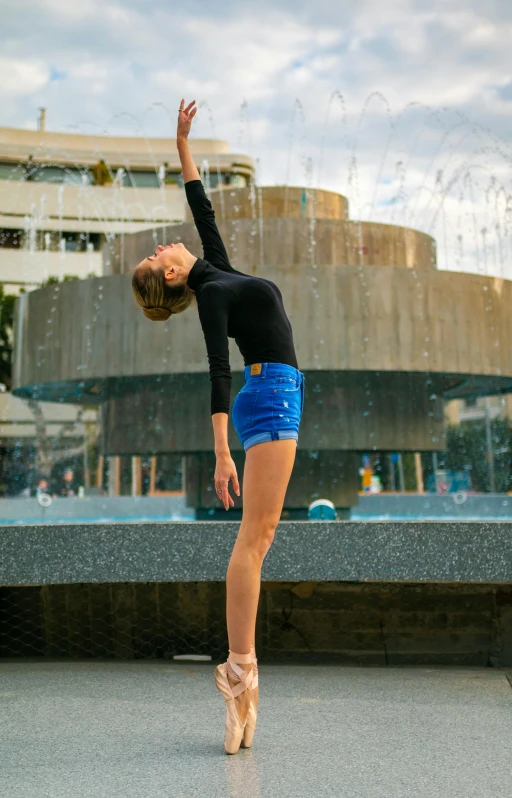 a woman is dancing in front of a fountain, inspired by Elizabeth Polunin, unsplash, high quality photo, tall angle, leotard, fullbody photo