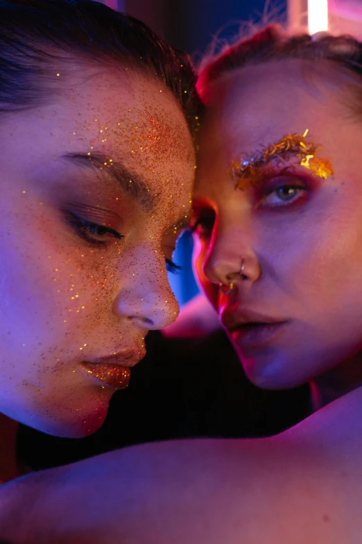 a couple of women standing next to each other, by Julia Pishtar, trending on pexels, holography, gold eyeshadow, glitter accents on figure, red neon eyes, pat mcgrath