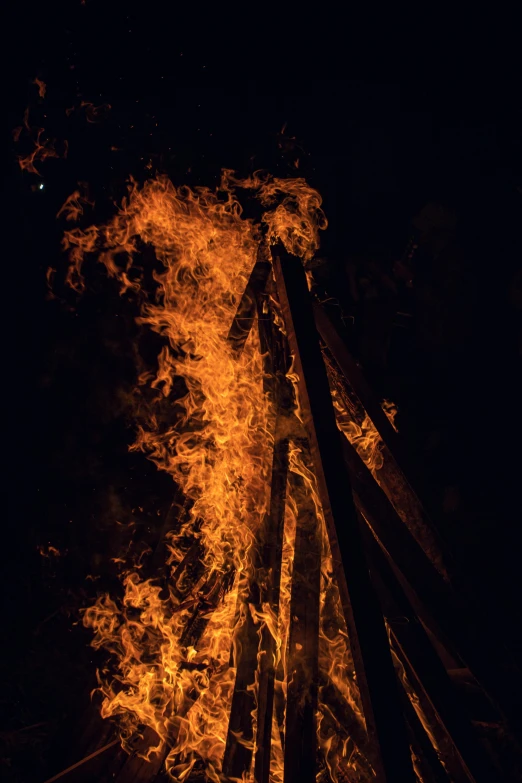 a bonfire is lit up in the dark, an album cover, unsplash, multiple stories, full frame image, tall, long