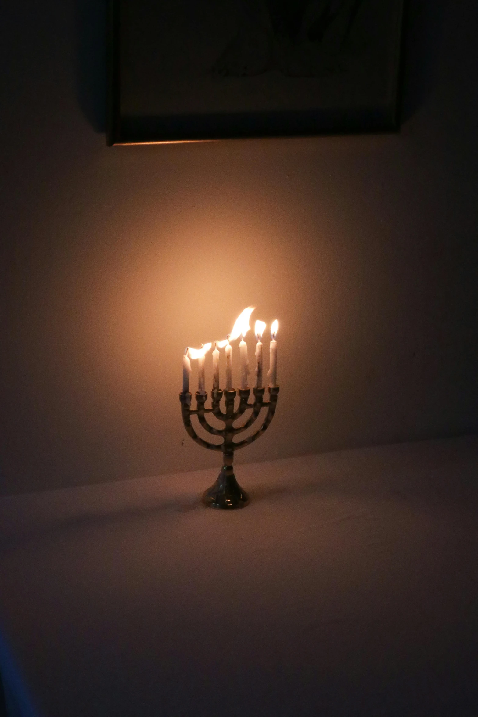 a lit up menorah sitting on top of a table, set on fire, taken in the late 2010s, jen atkin, melanchonic soft light