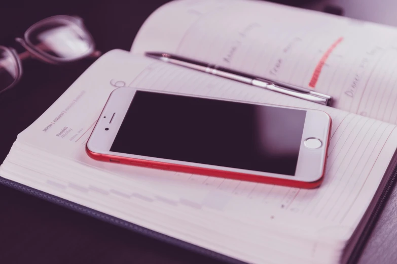 a cell phone sitting on top of an open book, trending on pexels, red monochrome, professional iphone photo, thumbnail