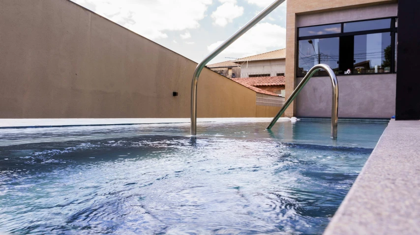 a hot tub filled with water next to a building, by Hirosada II, profile image, terracotta, sao paulo, sky blue