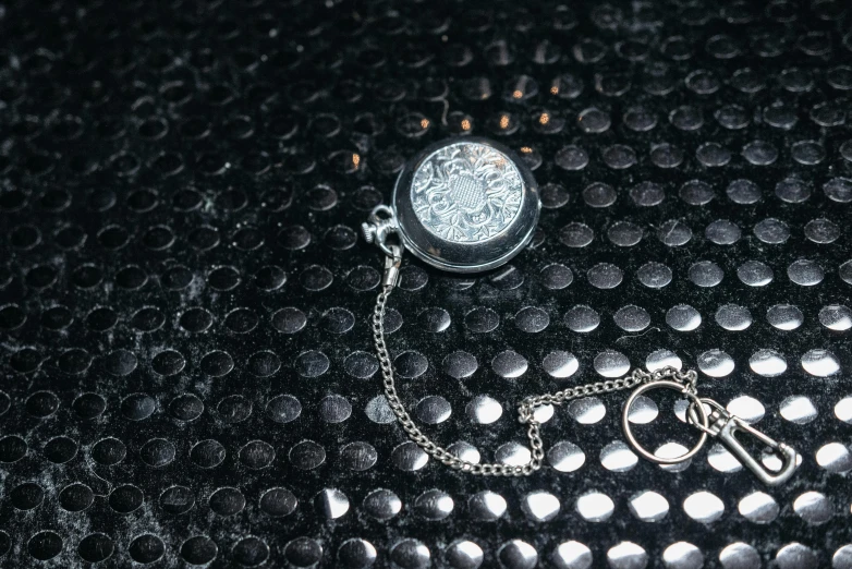 a close up of a pocket watch on a chain, an album cover, by Daniel Gelon, junya watanabe, fan favorite, lunar time, very tiny