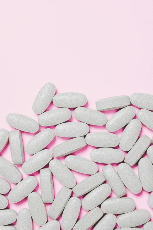 a pile of white pills on a pink background, trending on pexels, antipodeans, gray men, grey, 🎨🖌️, juice