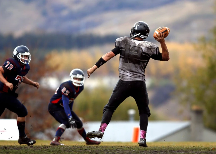 a group of young men playing a game of football, by Everett Warner, pexels contest winner, man standing in defensive pose, robotics, idaho, giants