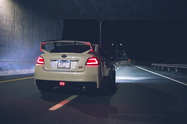 a car driving through a tunnel at night, a picture, unsplash, mingei, subaru, back arched, standing in a parking lot, modified