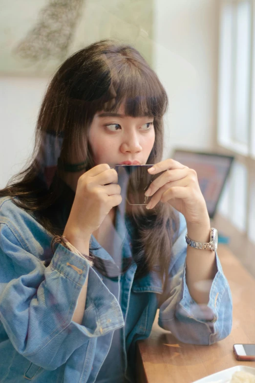 a woman sitting at a table with a cup of coffee, inspired by Kim Jeong-hui, pexels contest winner, happening, bangs and wavy hair, looking through frosted glass, ulzzang, profile image