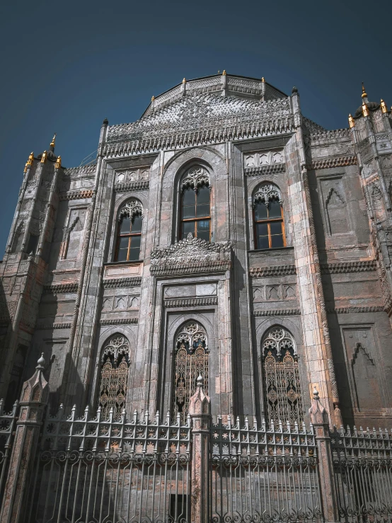 a large building with a gate in front of it, inspired by Gustav Doré, pexels contest winner, gothic church background, middle eastern details, color photo, grey