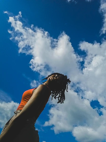 a woman is flying a kite in the sky, pexels contest winner, natural hair, under blue clouds, profile image, photo on iphone