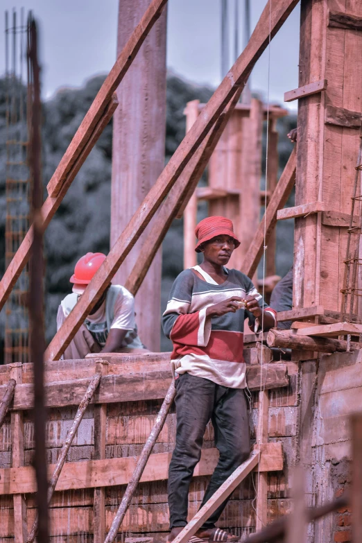 a group of men standing on top of a wooden structure, by Afewerk Tekle, pexels contest winner, renaissance, construction equipment 1 9 9 0, color footage, ethiopian, bending down slightly
