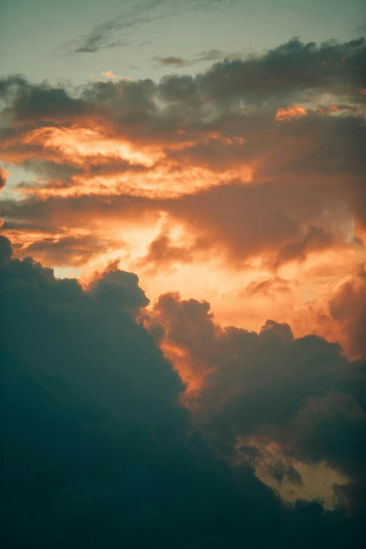 a plane flying through a cloudy sky at sunset, a picture, unsplash, romanticism, red cloud light, trending photo