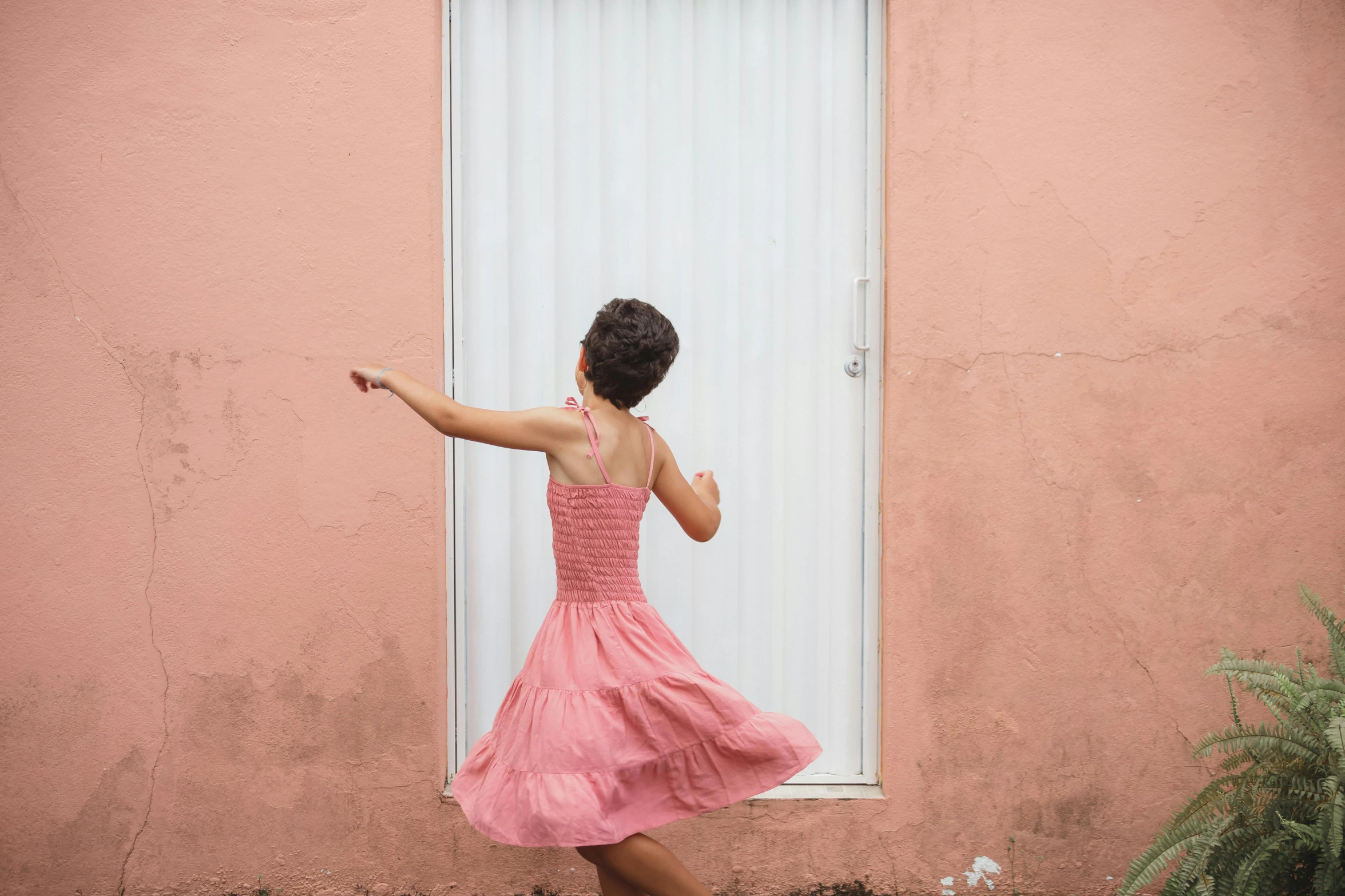 a woman in a pink dress standing in front of a window, by Lucia Peka, pexels contest winner, dancing a jig, puerto rico, dafne keen, on a wall