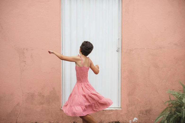 a woman in a pink dress standing in front of a window, by Lucia Peka, pexels contest winner, dancing a jig, puerto rico, dafne keen, on a wall