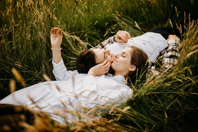 a couple laying on top of a lush green field, by Julia Pishtar, close - up photograph, high quality product image”, mixed art, picnic