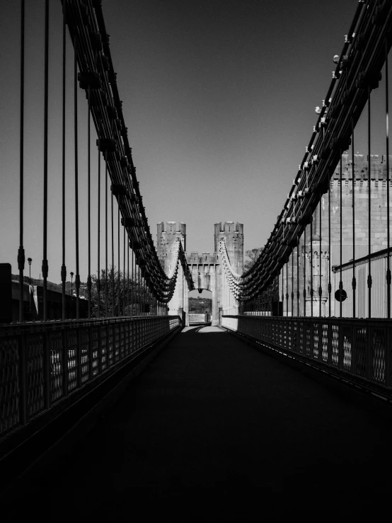 a black and white photo of a bridge, by Andrew Robertson, detailed medium format photo, connected with hanging bridge!!, by joseph binder, elegant walkways between towers