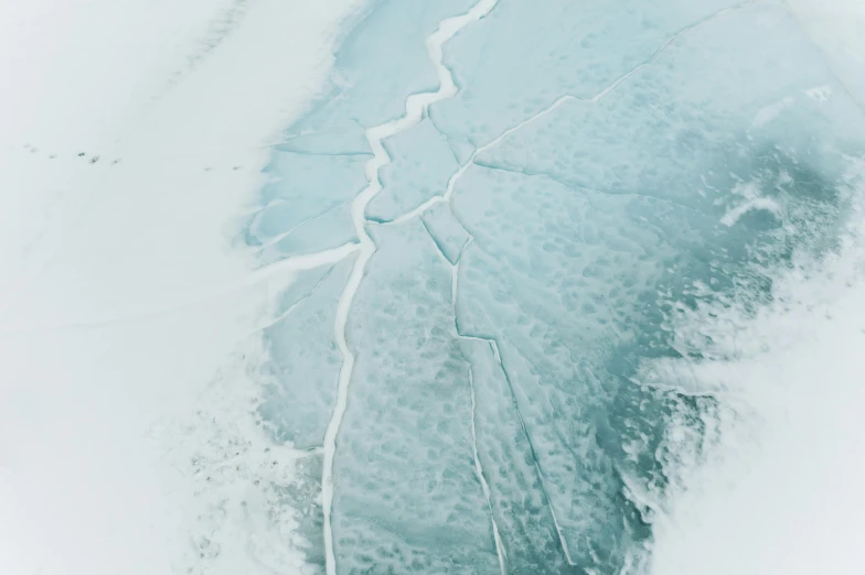 a man riding a snowboard down a snow covered slope, an album cover, inspired by Einar Hakonarson, pexels contest winner, analytical art, close-up print of fractured, cresting waves and seafoam, aerial view, female made of ice