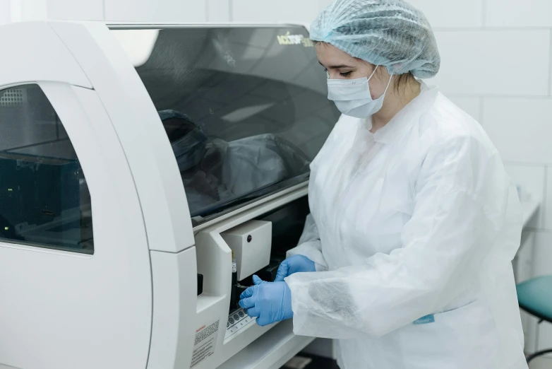 a woman in a lab coat putting something into a machine, premium quality, profile picture 1024px, high quality photo, the microchip