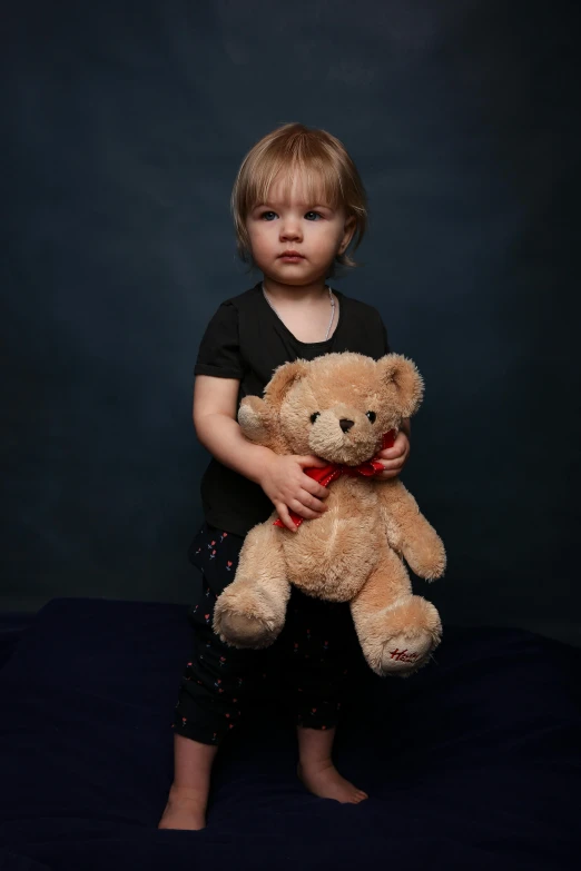 a little girl is holding a teddy bear, by David Simpson, process art, professional studio photograph, large, softplay, portrait image