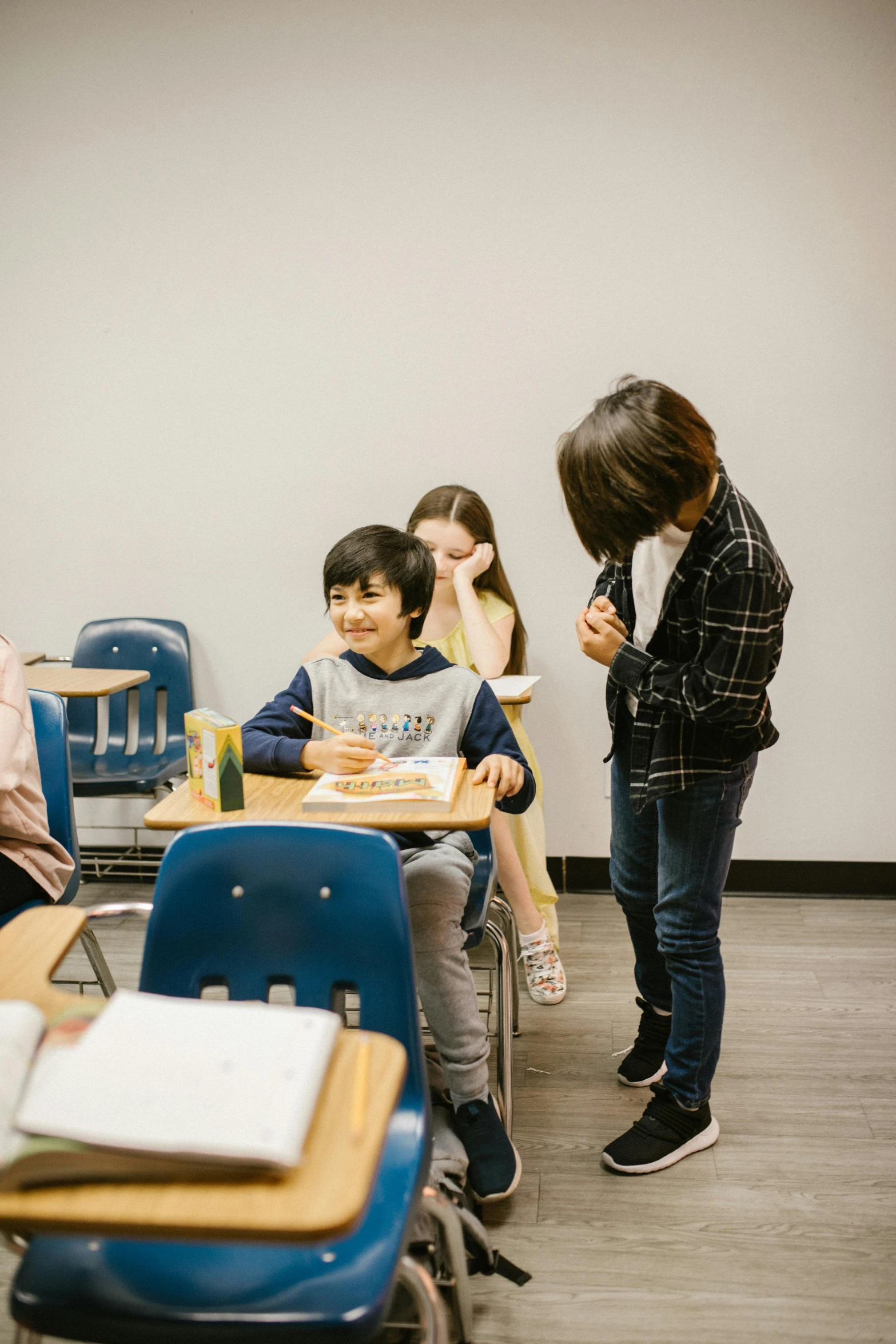 a group of children sitting at desks in a classroom, pexels contest winner, vancouver school, having a snack, calmly conversing 8k, low quality photo, full body image