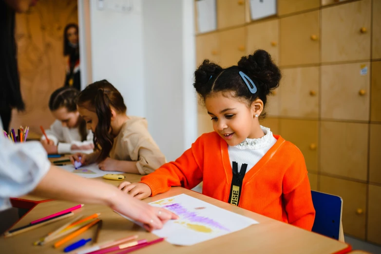 a little girl that is sitting at a table, pexels contest winner, danube school, wearing an orange t shirt, art stations, 278122496, teacher