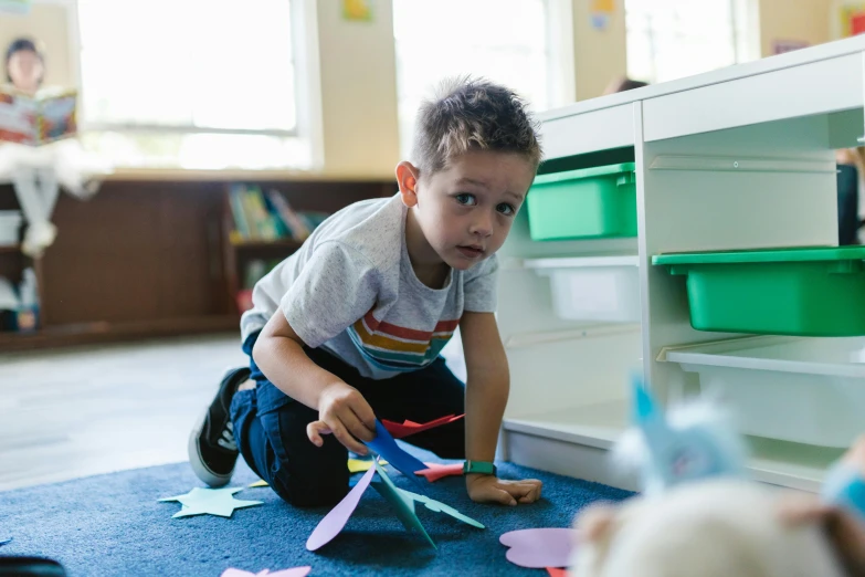 a little boy that is sitting on the floor, in a classroom, liam brazier, thumbnail, colour photograph