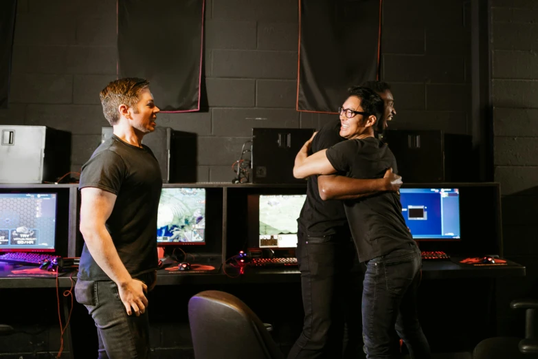 two men standing next to each other in front of computer monitors, unsplash, interactive art, hugs, riot games, lachlan bailey, 3 actors on stage