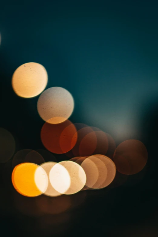 a blurry photo of a city at night, unsplash, light and space, smooth round shapes, soft light - n 9, circle forms, movie lights