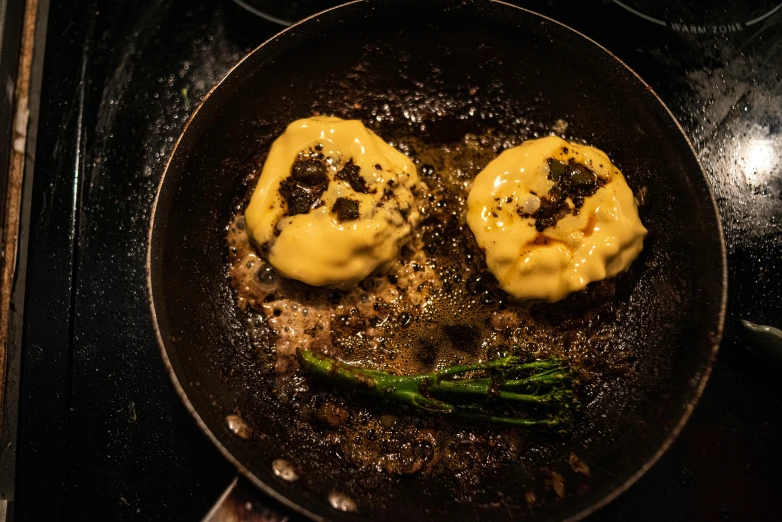 a frying pan filled with food sitting on top of a stove, oozing pustules, mustard, steamed buns, made of ferrofluid