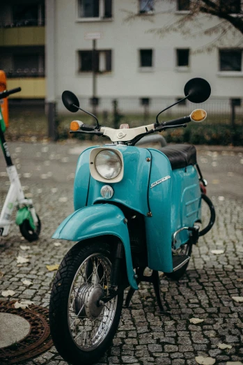 a blue scooter parked next to a white scooter, a colorized photo, unsplash, modernism, 🚿🗝📝, lower saxony, avatar image, brown and cyan color scheme